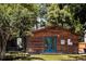 Charming home featuring stained wood cladding, blue French doors, and mature trees at 1878 S Gilpin St, Denver, CO 80210