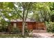 Charming home featuring wood siding, mature trees, a brick walkway, and an inviting front porch at 1878 S Gilpin St, Denver, CO 80210
