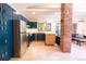 Bright kitchen featuring blue cabinets, stainless steel appliances, and brick accent wall at 1878 S Gilpin St, Denver, CO 80210