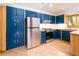 Modern kitchen featuring blue cabinets, stainless steel appliances, and lots of natural light at 1878 S Gilpin St, Denver, CO 80210