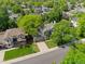 Aerial view of a home with mature trees, a driveway, and a well-maintained lawn in a suburban neighborhood at 20922 E Crestline Cir, Centennial, CO 80015