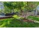 A serene backyard features a lush green lawn, mature trees, and a cozy deck with outdoor seating at 20922 E Crestline Cir, Centennial, CO 80015