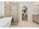 Bright bathroom featuring a soaking tub, walk-in shower with stylish tile, and a vanity with wood cabinetry at 20922 E Crestline Cir, Centennial, CO 80015