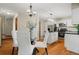 Open dining area featuring a glass table, white chairs, and hardwood floors at 20922 E Crestline Cir, Centennial, CO 80015