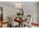 Stylish dining room with a wooden table, upholstered chairs, chandelier and view into the entry hall at 20922 E Crestline Cir, Centennial, CO 80015