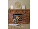 Close-up of a brick fireplace with mantel decor and a decorative flower arrangement at 20922 E Crestline Cir, Centennial, CO 80015