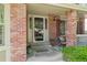 Cozy front porch featuring brick columns, a welcome mat, and decorative potted plants, creating an inviting entrance at 20922 E Crestline Cir, Centennial, CO 80015