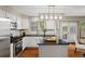 Modern kitchen featuring white cabinetry, black countertops, stainless steel appliances, and a central island at 20922 E Crestline Cir, Centennial, CO 80015