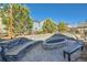 Backyard with a stone fire pit, built in seating and mature landscaping at 1715 Pioneer Cir, Lafayette, CO 80026