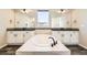 Bright bathroom with a large soaking tub, dual sinks, and modern black fixtures at 1715 Pioneer Cir, Lafayette, CO 80026