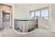 Hallway features an elegant curved railing, hardwood trim, and a pendant light fixture above at 1715 Pioneer Cir, Lafayette, CO 80026