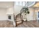 Elegant curved staircase with decorative iron railings and a tiled fireplace at 1715 Pioneer Cir, Lafayette, CO 80026