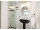 Modern bathroom with glass shower, black pedestal sink and updated lighting at 2000 Little Raven St # 501, Denver, CO 80202
