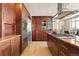 Gourmet kitchen with custom wood cabinetry, stainless steel appliances, and an island with cooktop at 2000 Little Raven St # 501, Denver, CO 80202