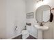 Cozy powder room with a pedestal sink, round mirror, and elegant fixtures at 4811 River Highlands Loop, Elizabeth, CO 80107
