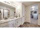 Bright bathroom featuring double sinks, granite counters, and a walk-in shower with modern fixtures, leading to the walk-in closet at 4811 River Highlands Loop, Elizabeth, CO 80107