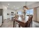 Inviting dining area featuring a large table, modern lighting, and seamless connection to the kitchen area at 4811 River Highlands Loop, Elizabeth, CO 80107