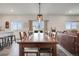 Spacious dining area with a large table, stylish lighting, and expansive windows with picturesque views at 4811 River Highlands Loop, Elizabeth, CO 80107