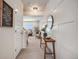 Bright hallway featuring wainscoting, neutral tones, a decorative mirror, and a glimpse of the living area at 4811 River Highlands Loop, Elizabeth, CO 80107