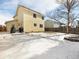 View of the home's backyard with snow-covered lawn and a fire pit feature at 13577 Quivas St, Denver, CO 80234