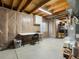 Unfinished basement featuring exposed wood beams, a work area, and storage space at 13577 Quivas St, Denver, CO 80234