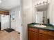 This bathroom features a single vanity with a green countertop, a mirror and a door to the outside at 13577 Quivas St, Denver, CO 80234