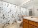 Cozy bathroom features a shower-tub combo with a decorative curtain, and a vanity with modern lighting at 13577 Quivas St, Denver, CO 80234