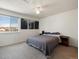 Bedroom with a comfortable queen-size bed, carpet flooring, and a large window providing natural light at 13577 Quivas St, Denver, CO 80234