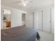 This bedroom includes carpet flooring, a gray quilted bedspread and an ensuite bathroom and closet at 13577 Quivas St, Denver, CO 80234
