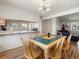 Inviting dining area features a wooden table with seating for six, and flows into the living room and kitchen at 13577 Quivas St, Denver, CO 80234