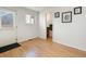 Hallway boasts laminate flooring and a rear door leading to the outside, plus a partial bathroom view at 13577 Quivas St, Denver, CO 80234