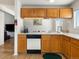 Efficient kitchen layout with wood cabinets, white countertops, and seamless access to other rooms at 13577 Quivas St, Denver, CO 80234
