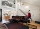 Spacious living room with high ceilings, a plush sofa, and a staircase leading to the upper level at 13577 Quivas St, Denver, CO 80234