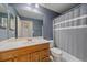 Bathroom featuring a light wood vanity, toilet, and shower with gray shower curtain at 2761 S Xanadu Way, Aurora, CO 80014