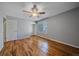 A bright bedroom featuring a ceiling fan, hardwood floors, and a large window offering natural light at 2761 S Xanadu Way, Aurora, CO 80014