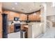 Charming kitchen with wood cabinets, granite counters, modern appliances, and breakfast bar at 3370 Cascina Cir # D, Highlands Ranch, CO 80126