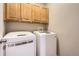 A convenient laundry room features a side-by-side washer and dryer and storage cabinets at 3370 Cascina Cir # D, Highlands Ranch, CO 80126