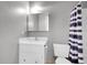 Compact bathroom with gray walls, white vanity, and blue-patterned shower curtain at 3355 S Flower St # 131, Lakewood, CO 80227