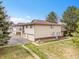 Side exterior of townhome featuring manicured lawn, private garage, and neutral siding at 3355 S Flower St # 131, Lakewood, CO 80227