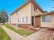 Two-story home with brick and vinyl siding and small landscaped front yard under a clear blue sky at 3355 S Flower St # 131, Lakewood, CO 80227