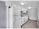 Well-maintained kitchen features white cabinets, appliances, and wood-look flooring at 3355 S Flower St # 131, Lakewood, CO 80227
