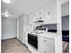 A bright kitchen features classic white cabinets and appliances, and light flooring at 3355 S Flower St # 131, Lakewood, CO 80227
