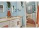 Charming blue bathroom featuring double sinks, modern fixtures, and a decorative shower curtain at 8422 S Upham Way # H75, Littleton, CO 80128