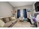 Comfortable bedroom with a gray sofa, cozy chair, and natural light from the window at 8422 S Upham Way # H75, Littleton, CO 80128
