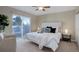 Cozy bedroom with a large bed, ceiling fan, and sliding glass doors leading to a deck at 8487 Everett Way # E, Arvada, CO 80005