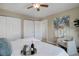 Bright bedroom features sliding closets, soft chair, and a tray with wine on the bed at 8487 Everett Way # E, Arvada, CO 80005