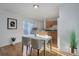 Modern dining area with sliding glass doors, white table set, hardwood floors, and open flow to the kitchen at 8487 Everett Way # E, Arvada, CO 80005