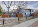 Charming blue townhome featuring a rustic wooden fence and mature trees at 8487 Everett Way # E, Arvada, CO 80005