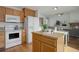 Bright kitchen blending into living space, with island, appliances, wood cabinets, ideal for entertaining at 8487 Everett Way # E, Arvada, CO 80005