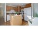 Functional kitchen with wooden cabinets, white appliances, a center island, and a clean, well-lit space for cooking at 8487 Everett Way # E, Arvada, CO 80005